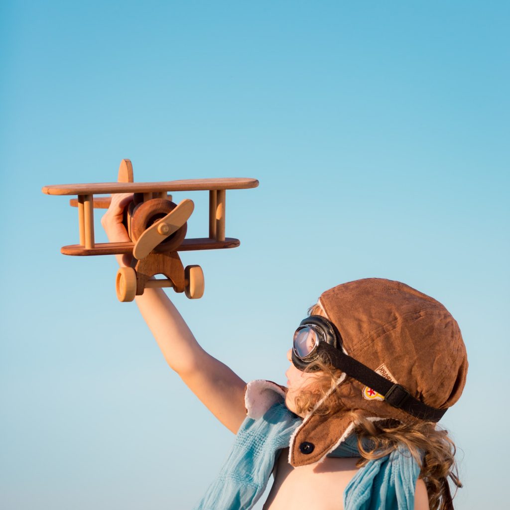 Happy kid playing with toy airplane