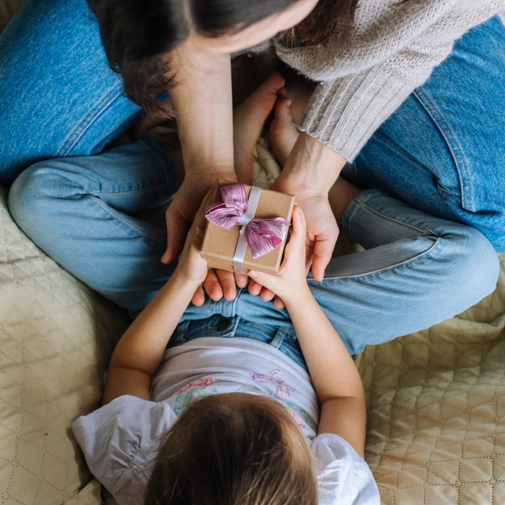 Little girl and her mother are giving a gift box