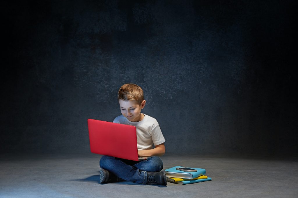 Little boy sitting with laptop in studio